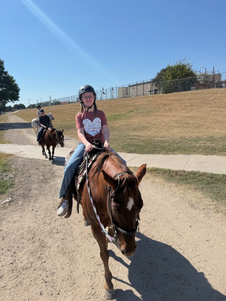 Girl riding horse in stockyards