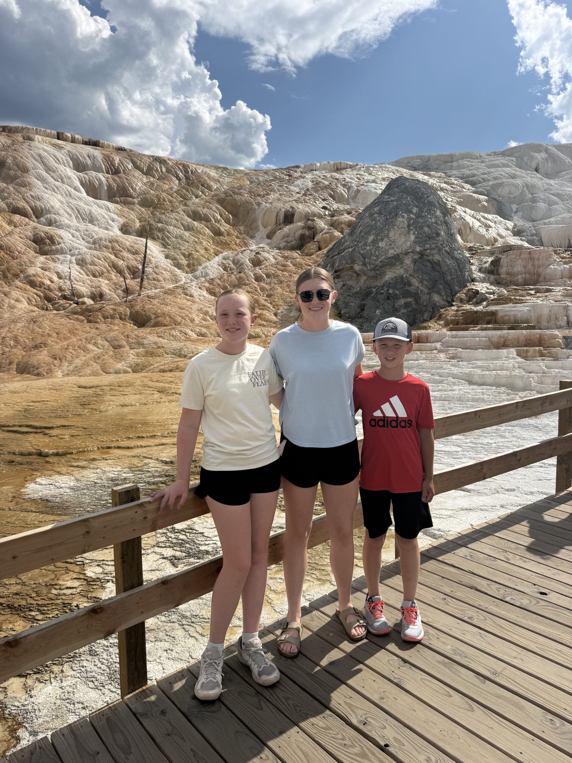 Two girls and a boy in front of Mammoth Springs